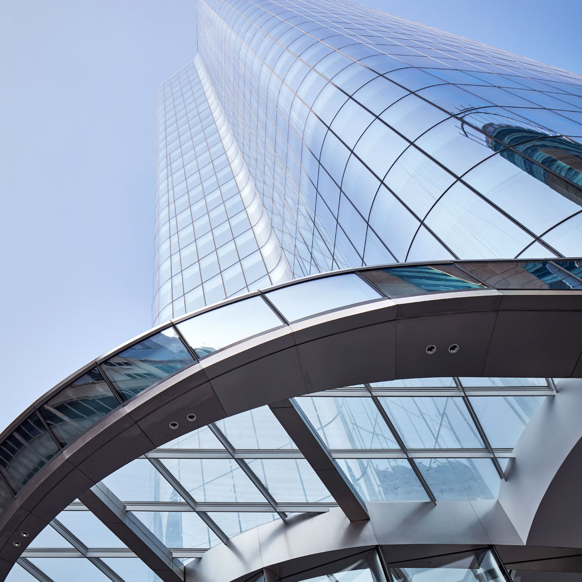 The modern office building, with its blue glass architecture, elegantly pierces the city's sky, embodying business dynamism.